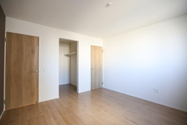 大字森町4期1号棟の洋室|シンプルで使いやすい洋室です。ナチュラルな木目の床とドアが空間を引き立てます。クローゼットが備わっており収納も便利です。壁や床の色合いが落ち着いた印象を与えます。室内全体が明るく感じられます。