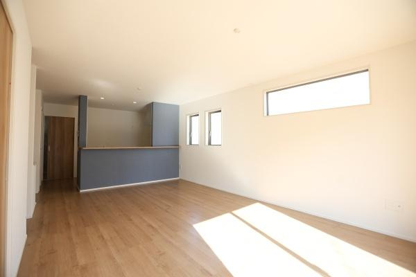 大字森町4期1号棟の居間・リビング|リビングには大きな窓があり日差しがたっぷりと差し込みます。ナチュラルなフローリングが空間を明るく演出しています。ダイニングとの一体感が感じられるレイアウトです。キッチンからもリビング全体が見渡せます。