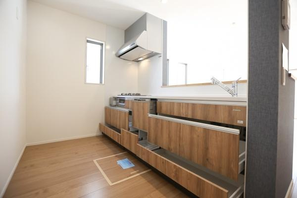 大字森町4期1号棟のキッチン|木目調デザインが印象的なキッチンです。収納が充実しており整理整頓がしやすい造りとなっています。窓から自然光が入り明るさが感じられます。使い勝手の良い空間設計が特徴です。