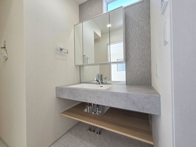 福岡市東区奈多1丁目第1-2棟（1号棟）の独立洗面台|毎日使うものだから清潔な空間を保ちたい水回り。洗面にはそんな願いを解消させてくれる収納アイデアが満載です。三面鏡の裏側にはキャビネットが現れ小物から背の高い物まで収納できます。