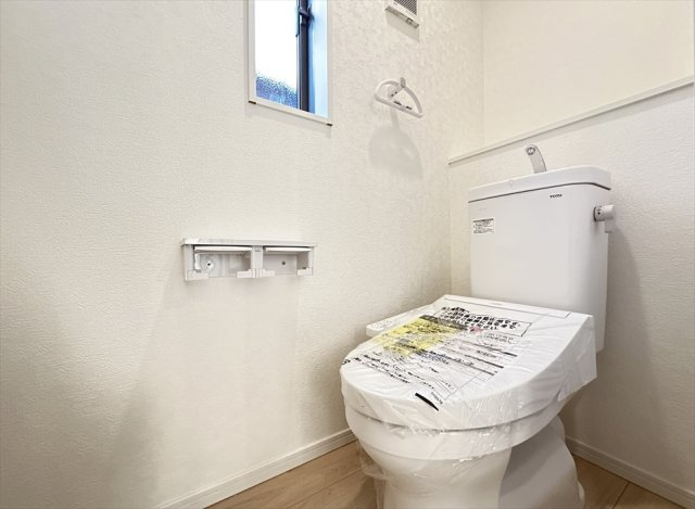 【トイレ】 | 新座市大和田5丁目　新築一戸建住宅　全1棟　(志木本店) | 家族を感染症から守る温水洗浄便座を完備。衛生用品やトイレットペーパー、掃除グッズの保管に便利な壁面収納もあるのでスッキリしたトイレ空間を維持できます。