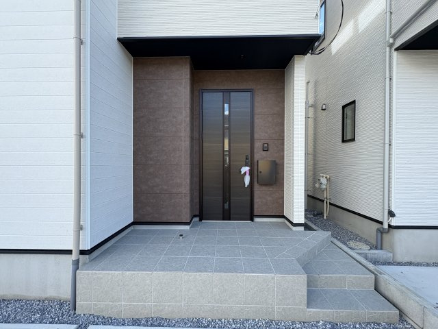 宇都宮市東峰町 ２期 新築住宅 全４棟の玄関|○玄関ポーチ○
 木目調の落ち着いた扉がおしゃれな玄関です♪開けた時の高級感がアパートと一味違うポイントです♪屋根があるので雨の日でも濡れにくい設計です♪
※2025年11月撮影