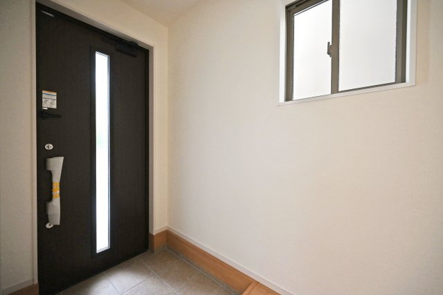 テラシエ福井町新築一戸建て全4区画│4LDK+駐車2台可の玄関|1階玄関をホール側から撮影した内観写真です。 シンプルな玄関扉にシューズボックス、小窓を配置したオーソドックスな玄関です。