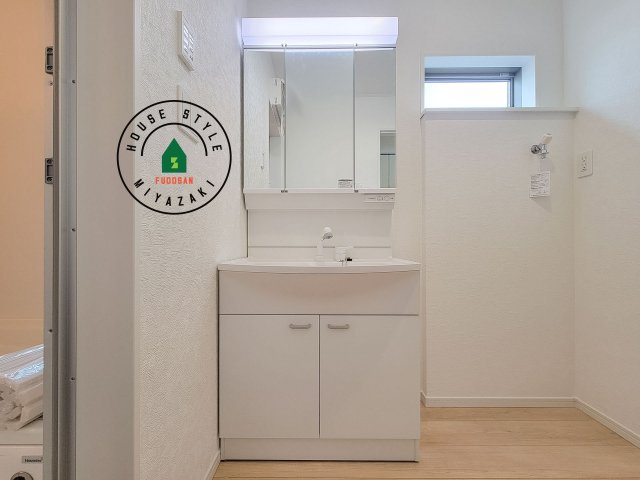 宮崎市熊野第4-2棟（2号棟）の独立洗面台|毎日使うものだから清潔な空間を保ちたい水回り。洗面にはそんな願いを解消させてくれる収納アイデアが満載です。三面鏡の裏側にはキャビネットが現れ小物から背の高い物まで収納できます。