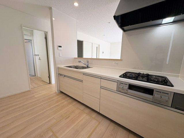 クレイドルガーデン糸満市宇江城 第2・１号棟のキッチン|キッチンの横には洗面室＆浴室があり、家事動線に優れた水廻り集中設計に