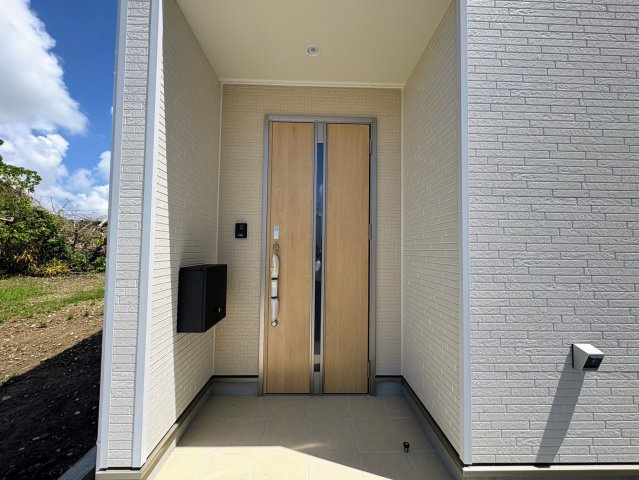 クレイドルガーデン糸満市宇江城 第2・１号棟の玄関|屋根付きで置配スペースも確保できる玄関ポーチ／人感センサー＆防犯カメラ＆TVモニター付きインターフォン設置