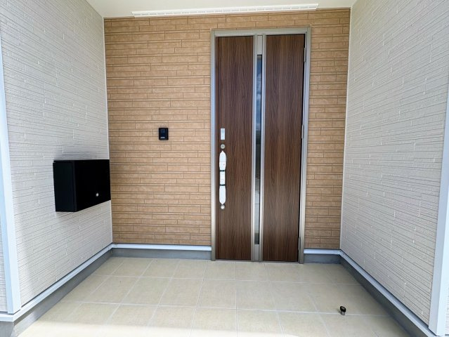 クレイドルガーデン糸満市宇江城 第2・2号棟の玄関|屋根付きで置配スペースも確保できる玄関ポーチ／人感センサー＆防犯カメラ＆TVモニター付きインターフォン設置