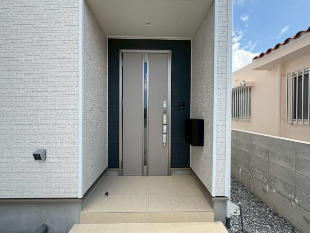 クレイドルガーデン糸満市宇江城 第2・5号棟の玄関|屋根付きで置配スペースも確保できる玄関ポーチ／人感センサー＆防犯カメラ＆TVモニター付きインターフォン設置