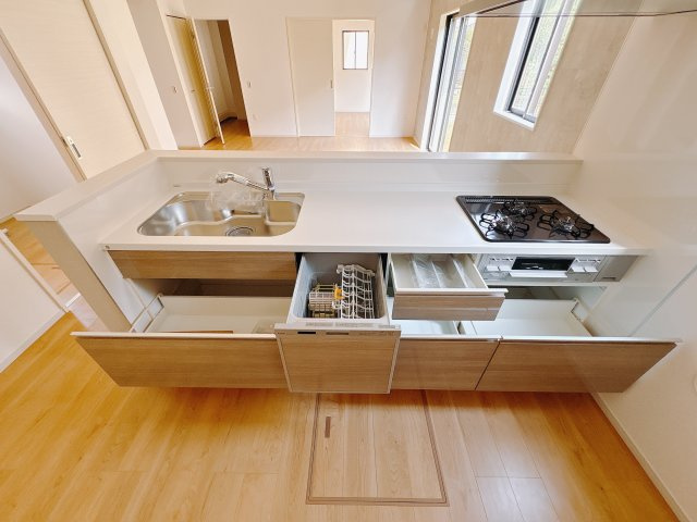 真岡市下高間木２期　新築住宅全２棟のキッチン|〇2号棟　キッチン〇
大きな鍋やフライパンを収納できるスライド収納が完備されています。また、カウンターが広いので作業がしやすく、シンクやコンロなどのお手入れがしやすい仕様です。
