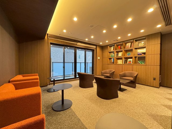 【ロビー】 | 【ラウンジ9】木調の壁にアーティスティックな配色の家具。ライトアップされた飾り棚が印象的。