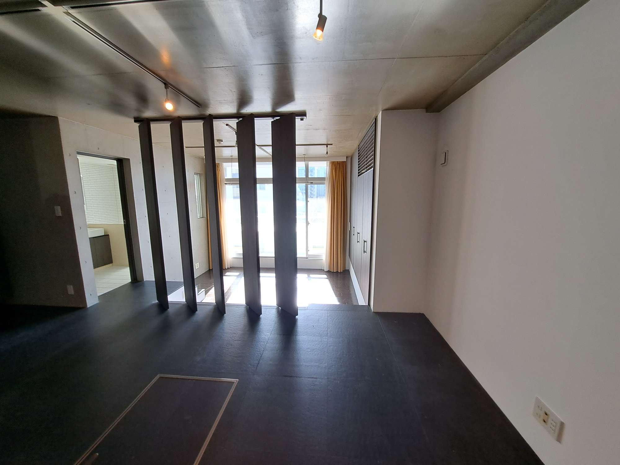 中央区日本橋小伝馬町の賃貸マンション|ルーバーの向こうは8.4帖の広さの洋室床がリビングより一段下がり天井高が2.8mとなります