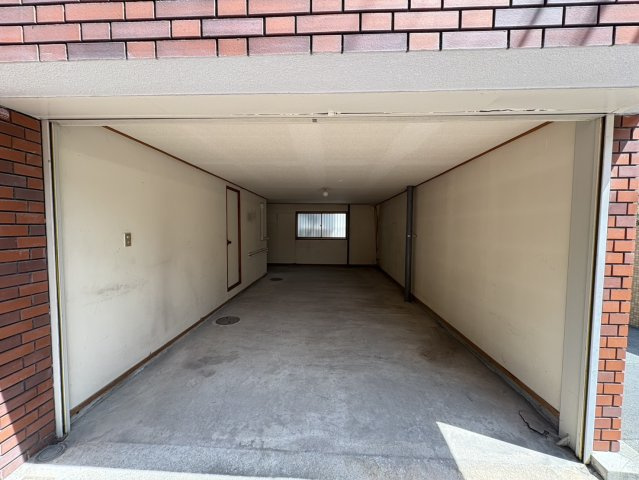 豊中市曽根西町3丁目　中古テラスハウスのその他|1階シャッター付ガレージには広々とした収納可能なスペースがございます。アウトドア用品などたくさん収納できます。西側から通路より【2025年8月22日撮影】