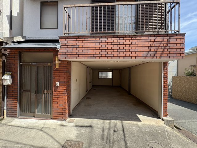 豊中市曽根西町3丁目　中古テラスハウスのその他|1階シャッター付ガレージには広々とした収納可能なスペースがございます。アウトドア用品などたくさん収納できます。北西側から通路より【2025年8月22日撮影】