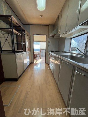 茅ヶ崎市浜竹4丁目　中古戸建のキッチン|一直線で作業しやすいキッチンスペース。窓と勝手口があり、明るさと動線を確保。