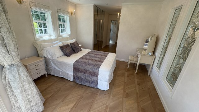 南軽井沢 白レンガが美しい新築戸建ての寝室|2F主寝室、約11帖。鏡張りのクローゼットが特徴的。南側と西側の2面採光。