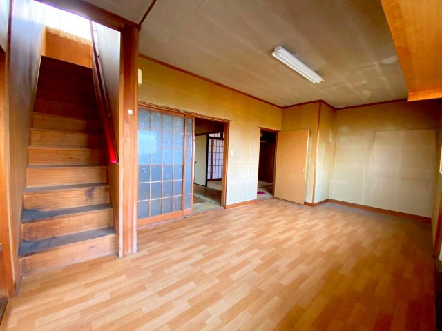 彦名町中古戸建の居間・リビング|ダイニング写真になり、2階への階段や水回りへのアクセス便利な間取りになります。