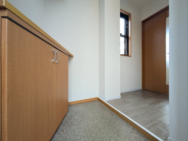 上鳴尾町20-11マンションの玄関|玄関。カウンター付きのシューズボックスと窓があります