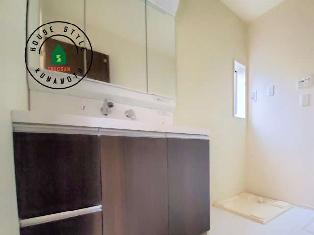 熊本市北区武蔵ケ丘2丁目第1-2棟（1号棟）の内観：施工例|毎日使うものだから清潔な空間を保ちたい水回り。洗面にはそんな願いを解消させてくれる収納アイデアが満載です。三面鏡の裏側にはキャビネットが現れ小物から背の高い物まで収納できます。