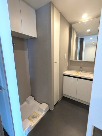 PROUD FLAT浅草の洗面所|トイレと独立した脱衣洗面室に洗濯機置場あります、洗濯機置場は排水口のお手入れしやすく手前中央に配置し、足高の防水パンです