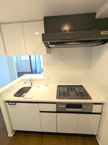 PROUD FLAT浅草のキッチン|グリル付ガス3口システムカウンターキッチン、瀟洒でお手入れ楽なガラストップコンロ、料理しやすいシンクカバー付です