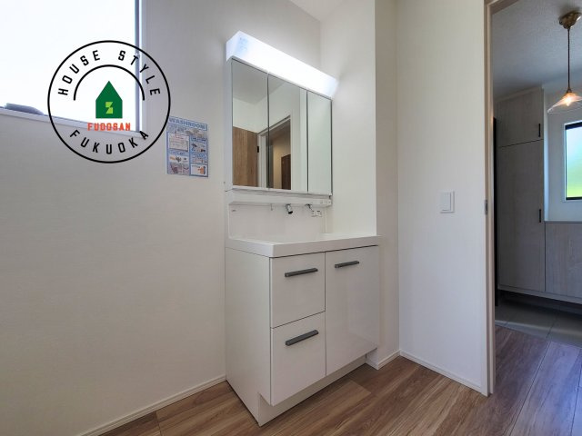 福岡市西区今津第10-3棟（2号棟）の独立洗面台|毎日使うものだから清潔な空間を保ちたい水回り。洗面にはそんな願いを解消させてくれる収納アイデアが満載です。三面鏡の裏側にはキャビネットが現れ小物から背の高い物まで収納できます。