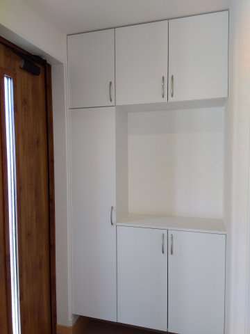 【新築戸建建売】八戸市長根4丁目の玄関|コの字型のシューズボックスは、空間に抜け感を持たせつつ、上部・側面に十分な収納を確保。オープンスペースに照明やグリーンを配置することで、より明るくwelcomingな玄関を演出♪