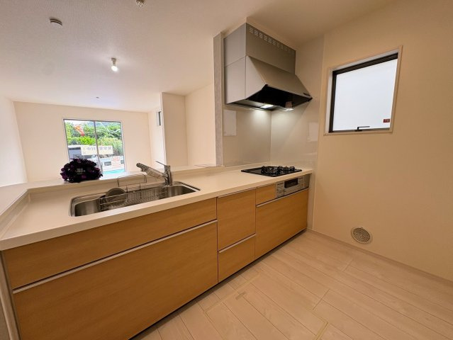 リーブルガーデン南城市佐敷新里・2号棟のキッチン|奥行き幅がありふたりでも料理がしやすい対面式のキッチン／換気窓＆床下収納