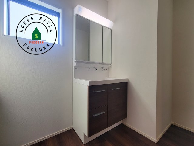 福岡市西区今津第14-4棟（1号棟）の独立洗面台|毎日使うものだから清潔な空間を保ちたい水回り。洗面にはそんな願いを解消させてくれる収納アイデアが満載です。三面鏡の裏側にはキャビネットが現れ小物から背の高い物まで収納できます。