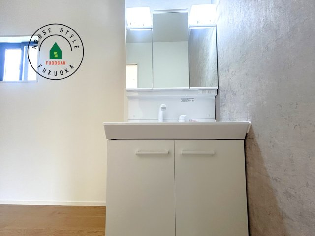 糸島市前原中央3丁目第1-3棟（1号棟）の内観：施工例|毎日使うものだから清潔な空間を保ちたい水回り。洗面にはそんな願いを解消させてくれる収納アイデアが満載です。三面鏡の裏側にはキャビネットが現れ小物から背の高い物まで収納できます。