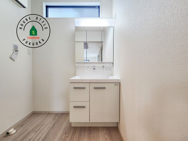 古賀市千鳥6丁目第1-2棟（1号棟）の独立洗面台|毎日使うものだから清潔な空間を保ちたい水回り。洗面にはそんな願いを解消させてくれる収納アイデアが満載です。三面鏡の裏側にはキャビネットが現れ小物から背の高い物まで収納できます。