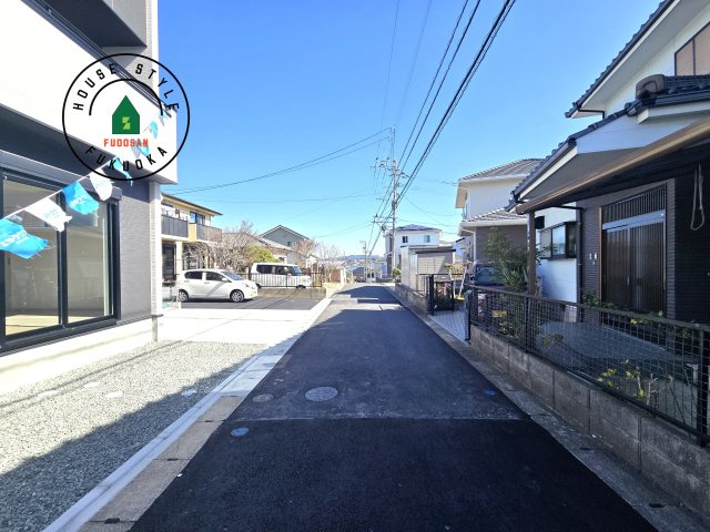 古賀市千鳥6丁目第1-2棟（1号棟）の前面道路含む現地写真|前面道路は閑静な住宅地をはしる車通りの少ない道路。お車の出し入れが苦手なママや小さなお子様にも安心ですね。しっかり舗装もされているので、ベビーカーや自転車で通っても快適に通行できます。
