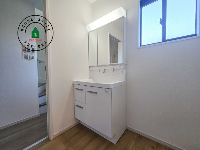 太宰府市青山2丁目第3-2棟(1号棟)の独立洗面台|毎日使うものだから清潔な空間を保ちたい水回り。洗面にはそんな願いを解消させてくれる収納アイデアが満載です。三面鏡の裏側にはキャビネットが現れ小物から背の高い物まで収納できます。