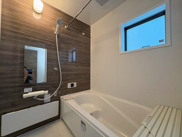 リーブルガーデン南城市佐敷新里・3号棟の浴室|浴室換気暖房乾燥機付きユニットバス／物干し竿＆浴室窓付き