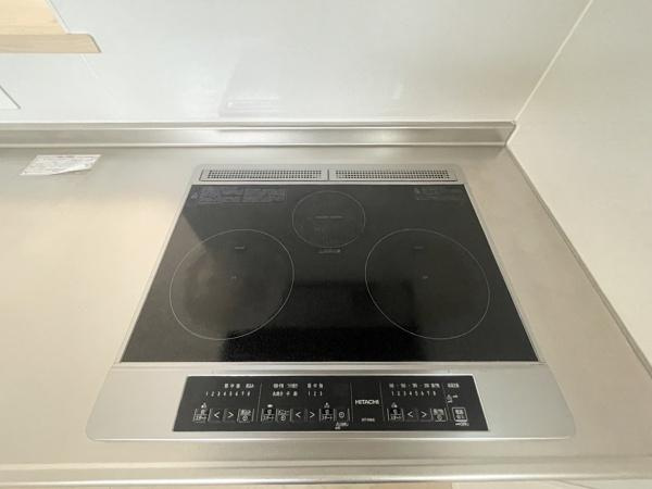 横塚1丁目　中古のキッチン|IHクッキングヒーターが設置されたキッチンです。フラットな天板はお手入れが簡単です。シンプルなデザインで使いやすさに配慮されています。調理スペースも広く確保されています。