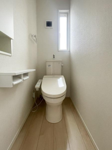 横塚1丁目　中古のトイレ|明るい採光があるトイレです。アクセントのある壁面収納が便利に配置されています。ゆとりを持ったレイアウトが印象的です。温水洗浄便座が備わった仕様となっています。