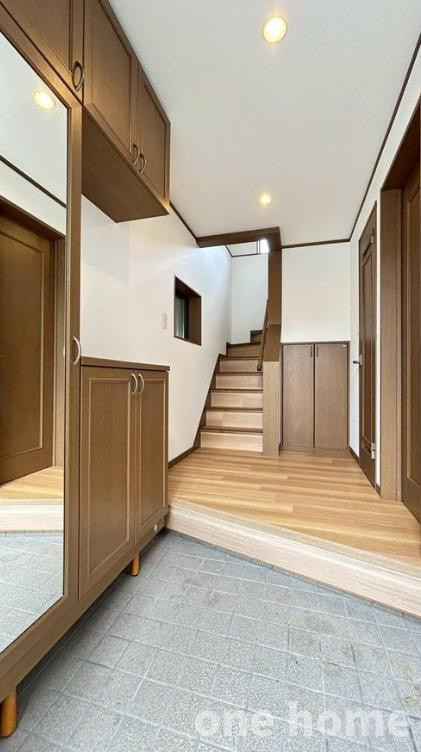 西三国3丁目中古戸建の玄関|◆玄関は木目の内装で統一され、落ち着いた雰囲気です！
◆大容量シューズボックス完備！大きな姿見もあり、お出かけ前の身支度チェックもバッチリです！