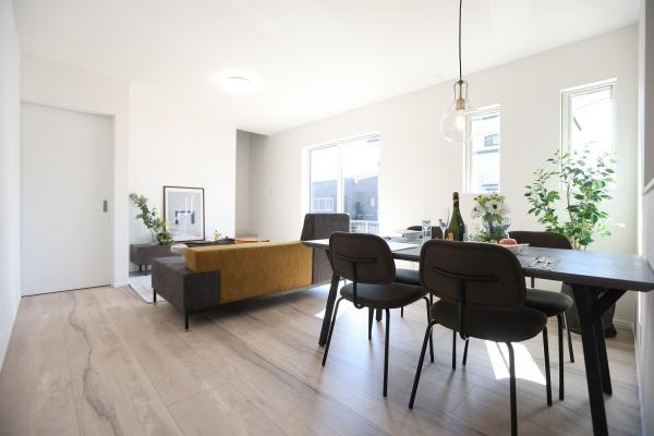 横尾　新築の居間・リビング|大きな窓から明るい光が差し込むリビングはキッチンからも目が届きやすい配置がされています。ゆったりとした空間が広がっています。