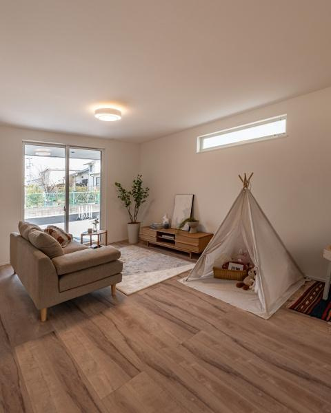 小佐井Ｎ新築の居間・リビング|大きな窓から光が差し込むリビングは明るい雰囲気が広がっています。木目調の床がナチュラルで落ち着いた印象です。