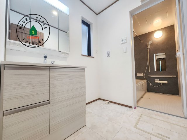 福岡市早良区飯倉6丁目第1-1棟（A号棟）の脱衣所|ゆとりの洗面スペースで朝の身支度もスムーズに。暮らしを快適に変えるシャワー付洗面台です！