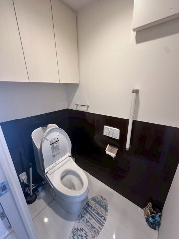 豊見城市字豊見城の中古マンションのトイレ|収納棚＆手すり付きのトイレ／温水洗浄便座