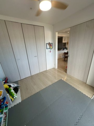 豊見城市字豊見城の中古マンションの洋室|リビングに隣接する洋室／アクセントクロス＆収納力抜群のクローゼット付き