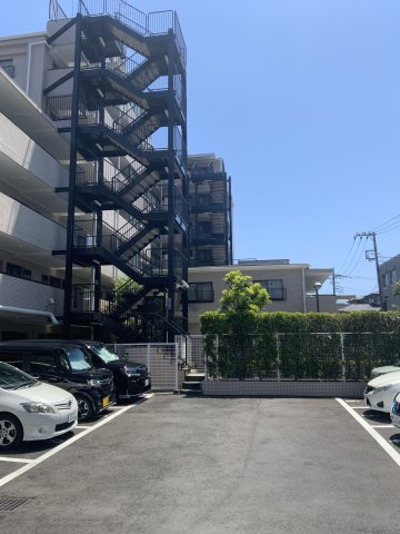 シーアイマンション新小岩親水公園の駐車場|駐車場や外階段などがきちんと整えられていて、管理の行き届いた安心感があります。特に外階段の黒フレームが建物全体を引き締め、スタイリッシュさを感じます。