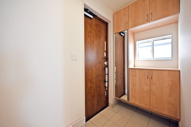 ブルーミングガーデン安倉中4丁目新築一戸建て│3LDK+駐車1台可の玄関|1階玄関をホール側から撮影した内観写真です。 シンプルな玄関扉にシューズボックス、小窓を配置したオーソドックスな玄関です。