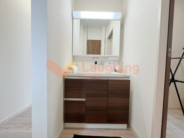 梅満町平屋戸建の独立洗面台|木目調キャビネットの洗面化粧台。三面鏡収納付きで、見た目も使い勝手も良いデザインです。