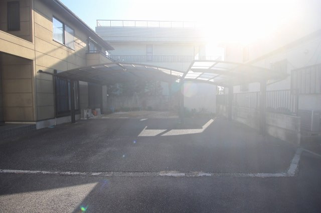 小山市神鳥谷2丁目の駐車場|屋根付きの駐車スペースを備え、雨の日の乗り降りも安心。敷地にゆとりがあり、車の出し入れもしやすい配置です。