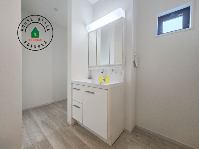 春日市塚原台2丁目第1-1棟（1号棟）　の独立洗面台|毎日使うものだから清潔な空間を保ちたい水回り。洗面にはそんな願いを解消させてくれる収納アイデアが満載です。三面鏡の裏側にはキャビネットが現れ小物から背の高い物まで収納できます。