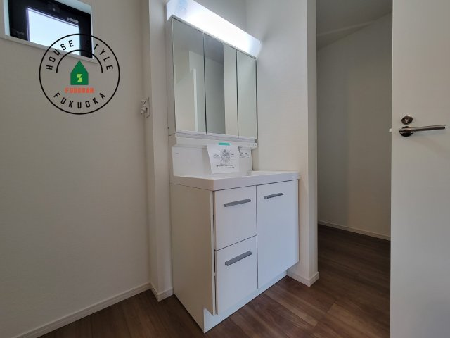 大野城市畑ケ坂第1-3棟（2号棟）　の独立洗面台|毎日使うものだから清潔な空間を保ちたい水回り。洗面にはそんな願いを解消させてくれる収納アイデアが満載です。三面鏡の裏側にはキャビネットが現れ小物から背の高い物まで収納できます。