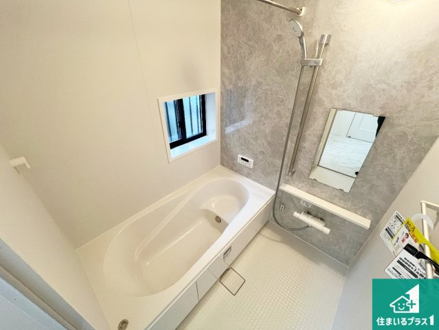 明石市中朝霧丘　新築一戸建ての浴室|足をゆったり伸ばして寛げる浴槽です。窓が設けられていますので差し込む光が明るく穏やかな雰囲気にしてくれます♪浴室乾燥機も設置しているので、雨の日の洗濯物も安心です♪