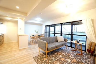 【居間・リビング】 |  【上質リノベ】ダイアパレスパークサイド府中 | 【約15.4帖LDK】
今回のリノベーションスタイルは「ナチュラル」
自然素材や木材を使用したような、明るく優しい雰囲気が特徴です。
窓からたっぷり入る自然光が、お部屋の雰囲気を引き立てます。