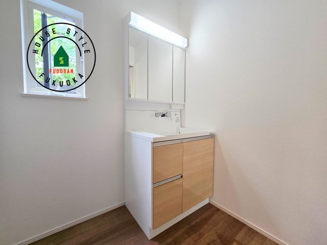 糸島市篠原西1丁目第2-2棟（2号棟）　の独立洗面台|毎日使うものだから清潔な空間を保ちたい水回り。洗面にはそんな願いを解消させてくれる収納アイデアが満載です。三面鏡の裏側にはキャビネットが現れ小物から背の高い物まで収納できます。